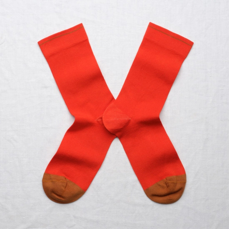 Red socks with brown toes and heels on a light gray background