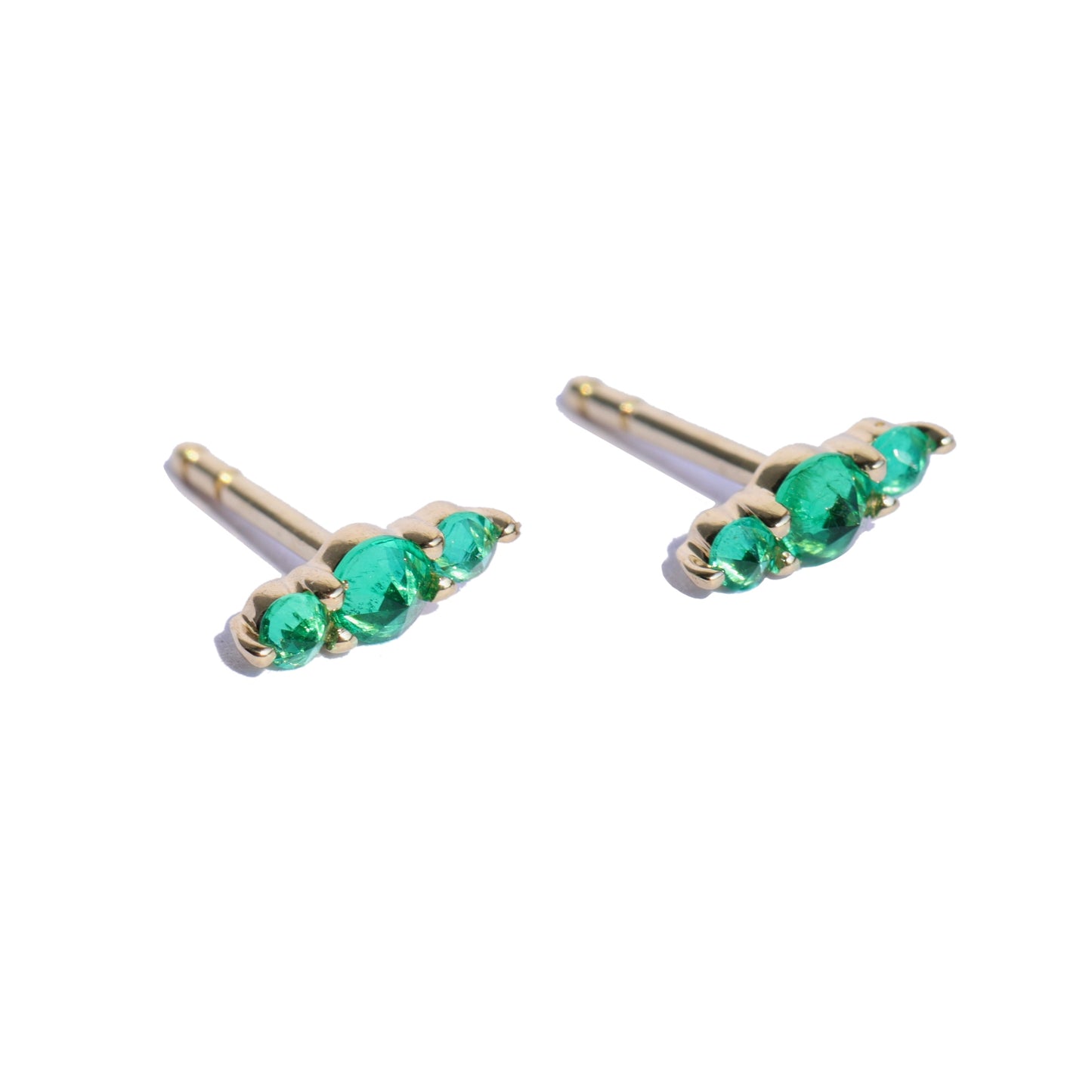 pair of stud earrings with three emeralds in each