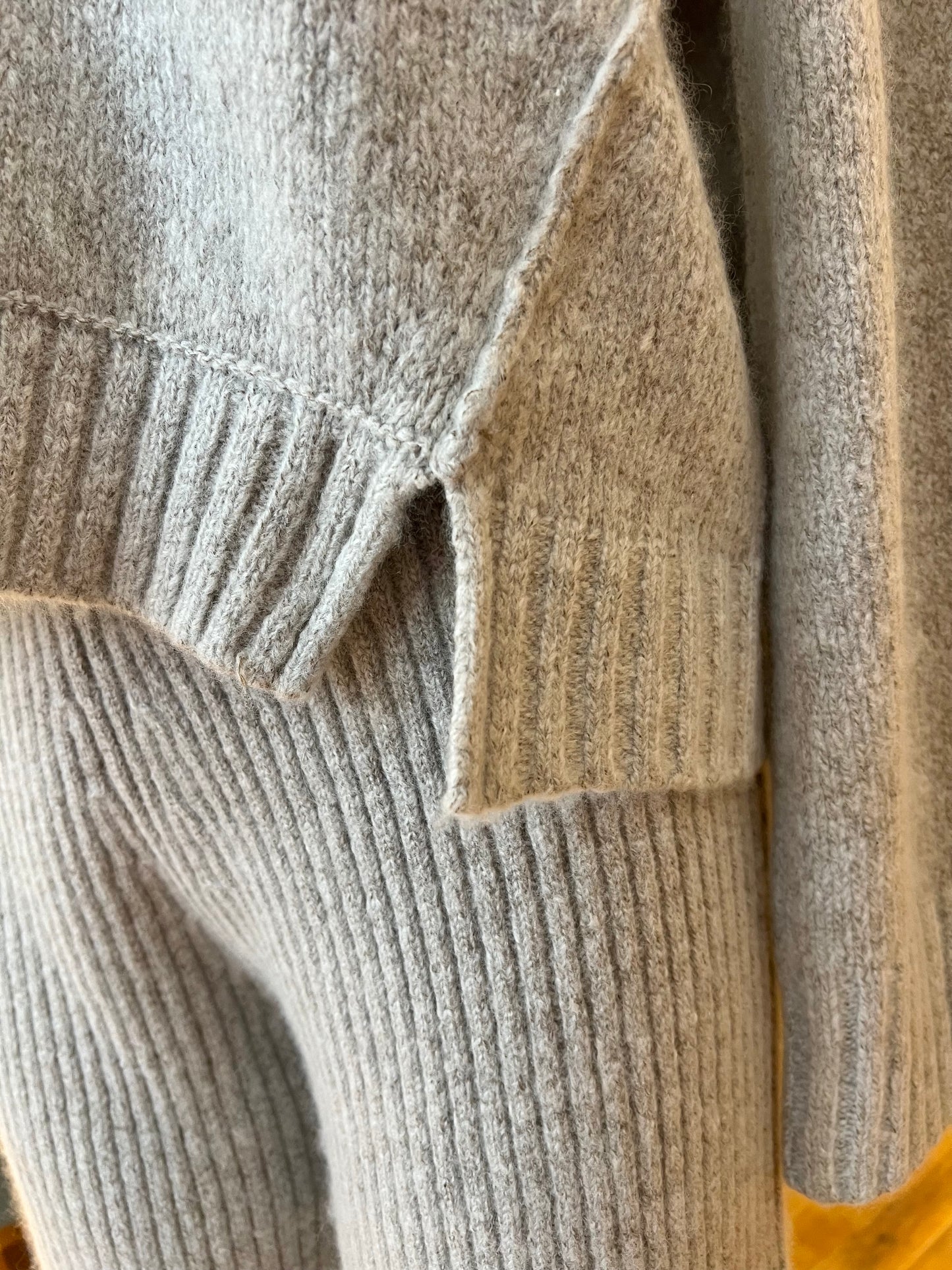Close-up of a textured sweater with a focus on the collar and sleeve.