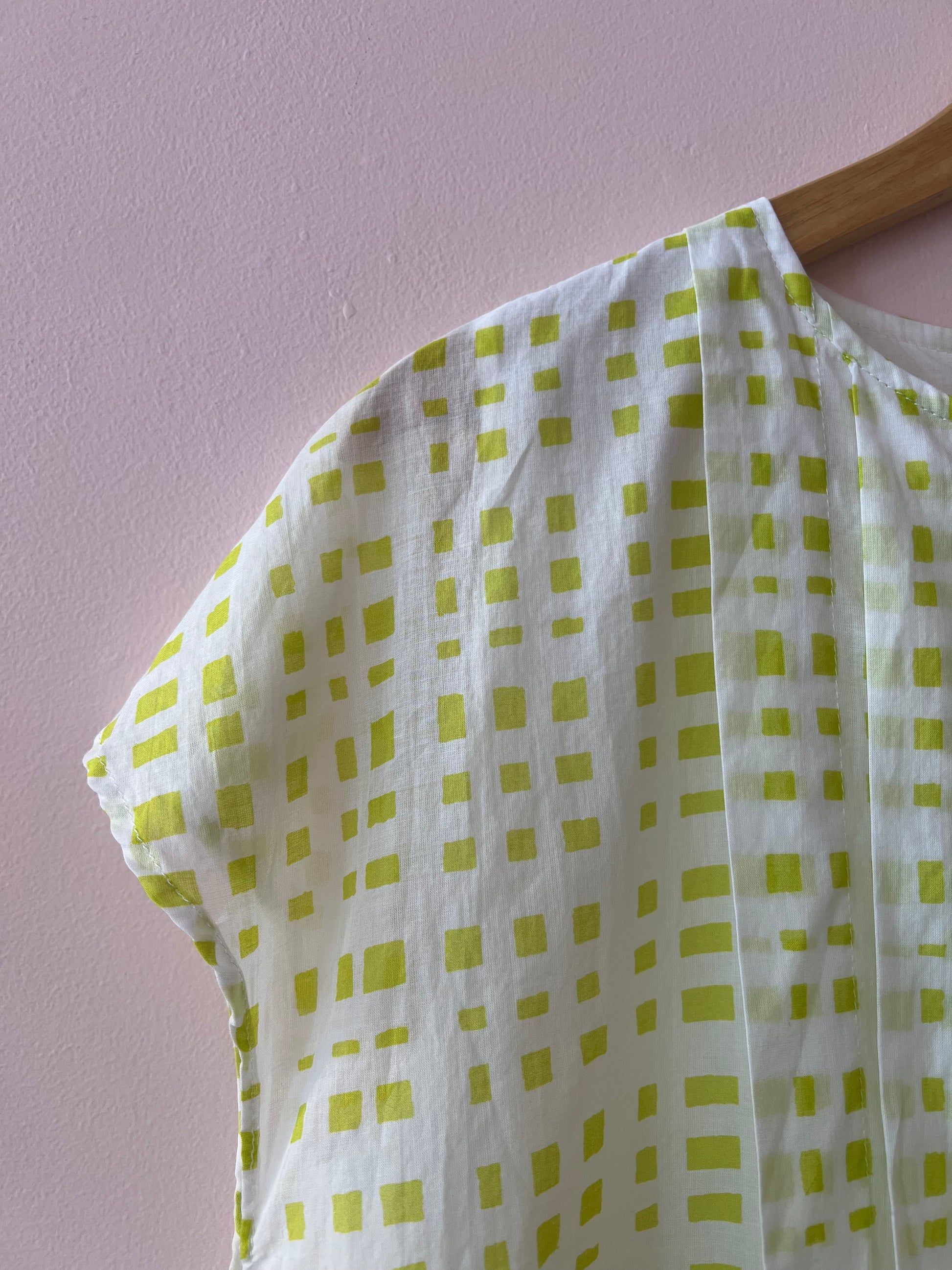 Green and white checkered fabric on a pink background