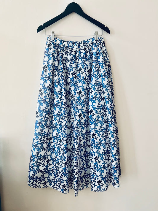 Floral skirt with blue and white pattern on a hanger against a plain background