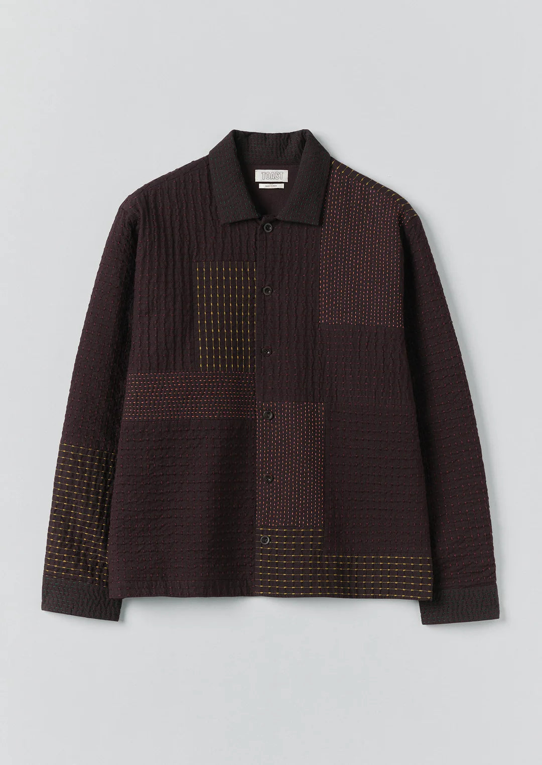 Brown textured shirt with geometric patterns on a light gray background