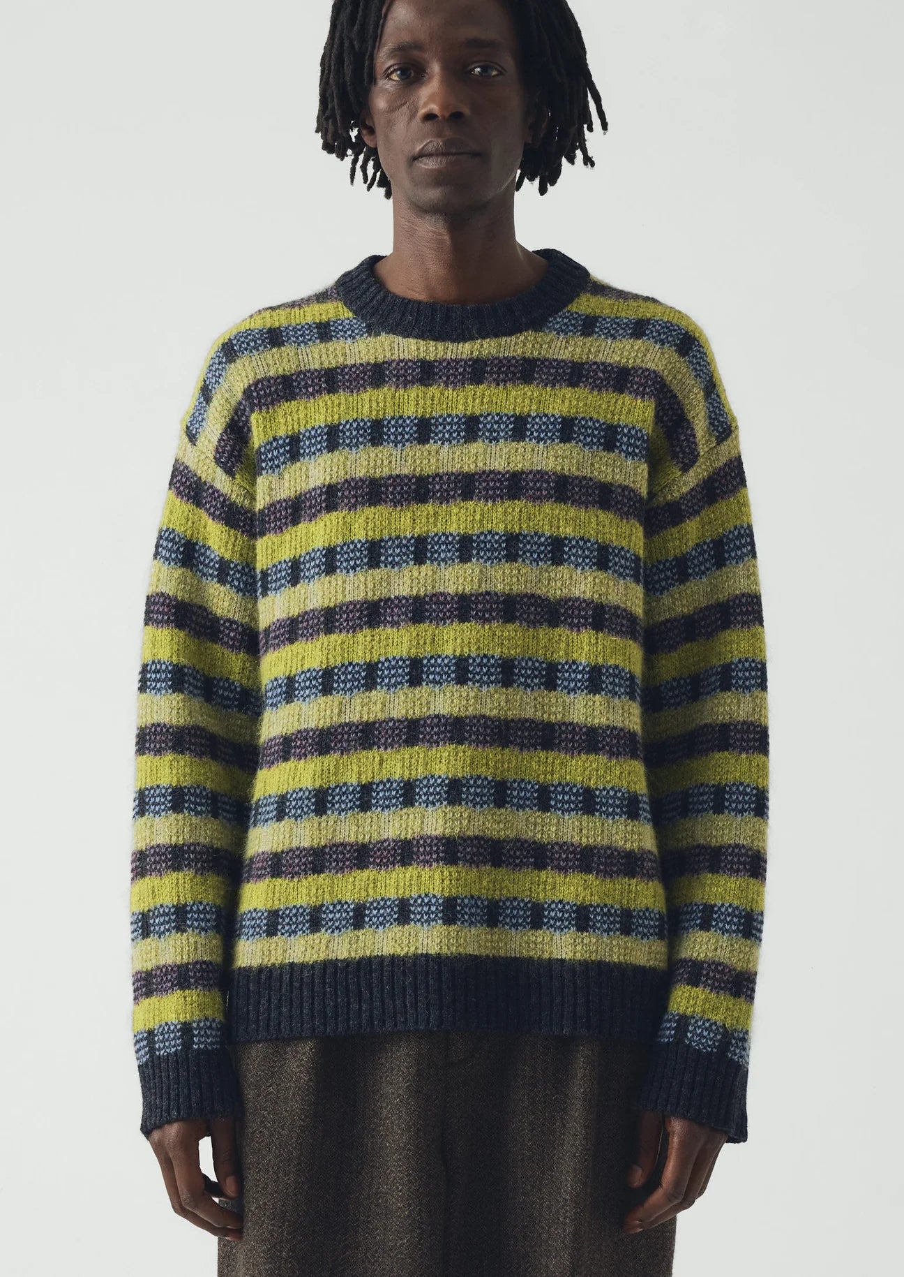 Image of man wearing a blue and green sweater