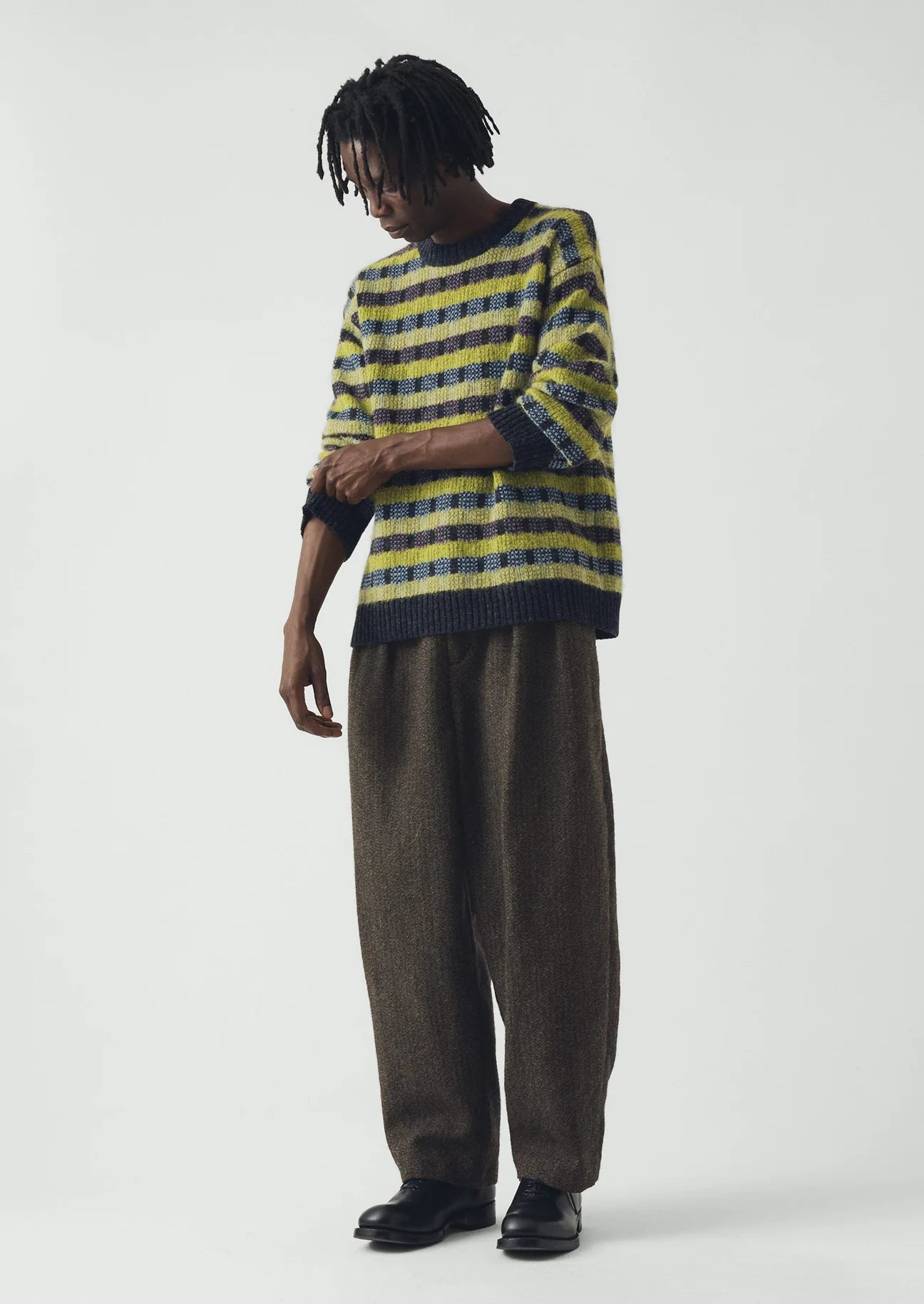 Full length image of man wearing a blue and green sweater