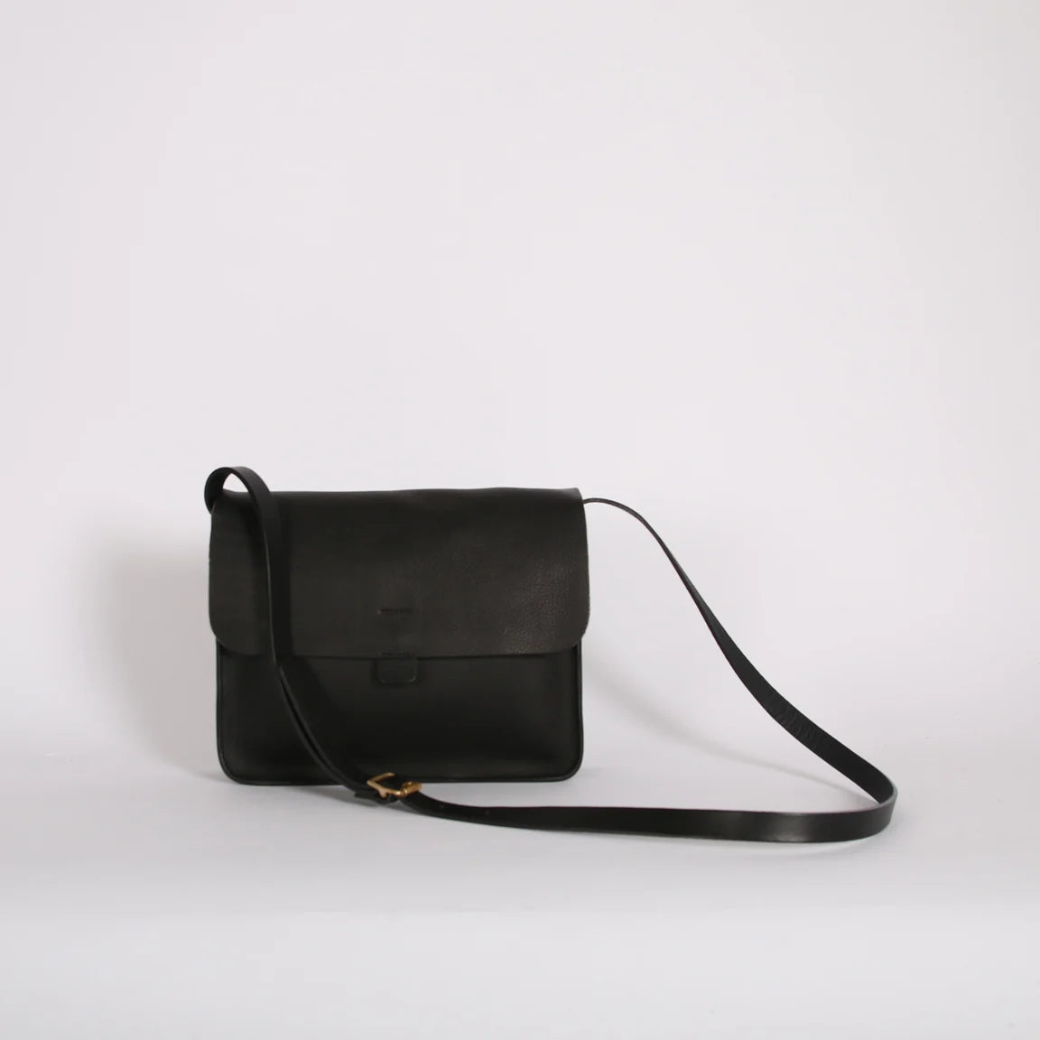 Black leather bag with shoulder strap on white background