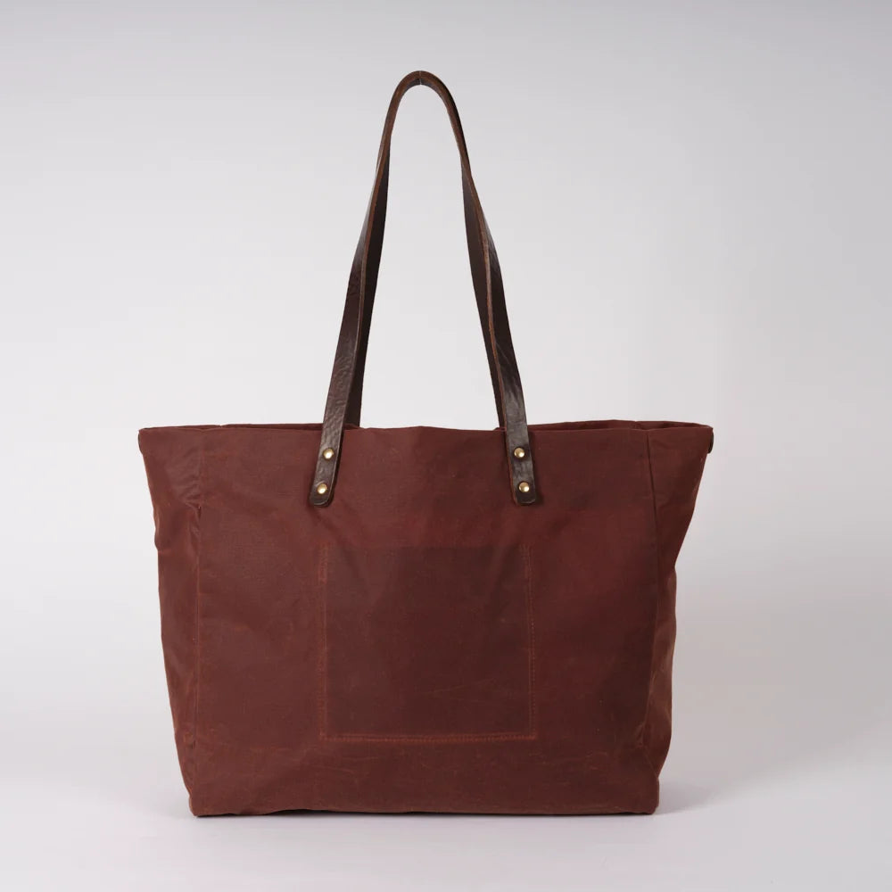 Brown tote bag with leather handles on a white background