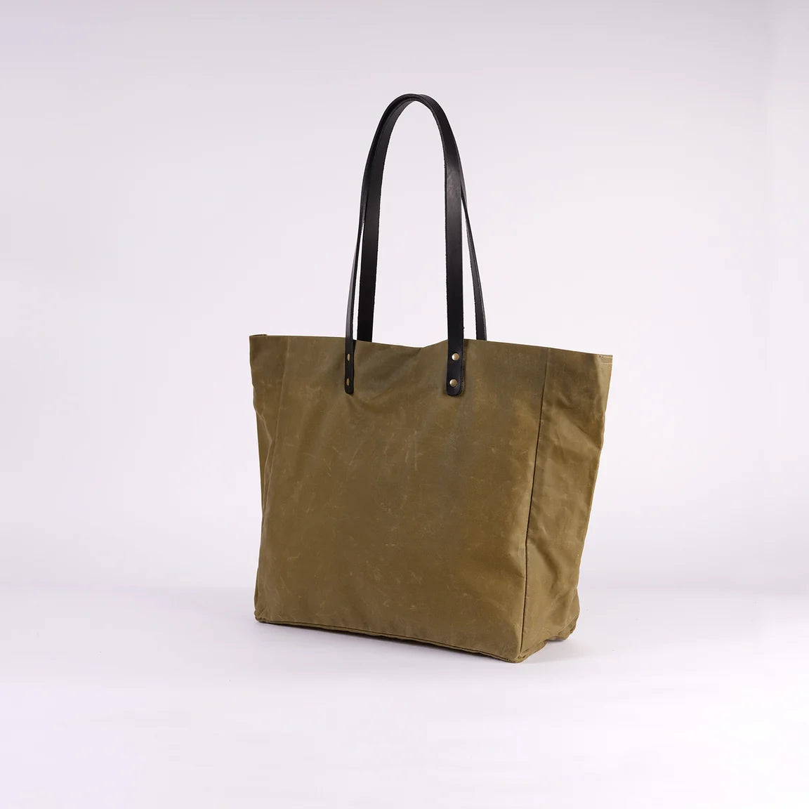 Green tote bag with black handles on a white background
