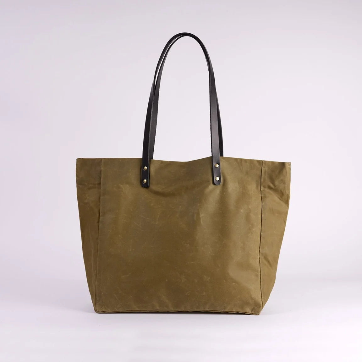 Green tote bag with black handles on a white background