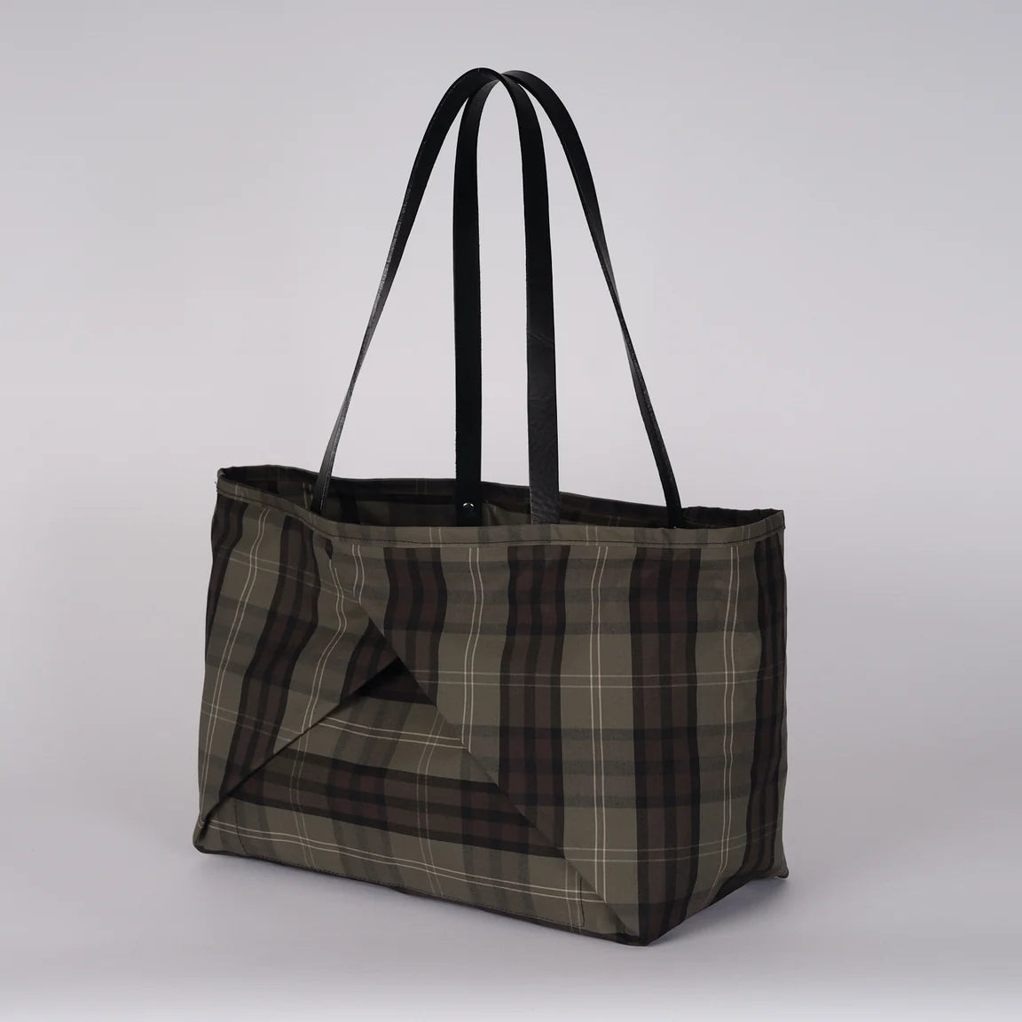 A large tote bag with a brown, gray, and black plaid pattern and black shoulder straps, shown against a plain white background.