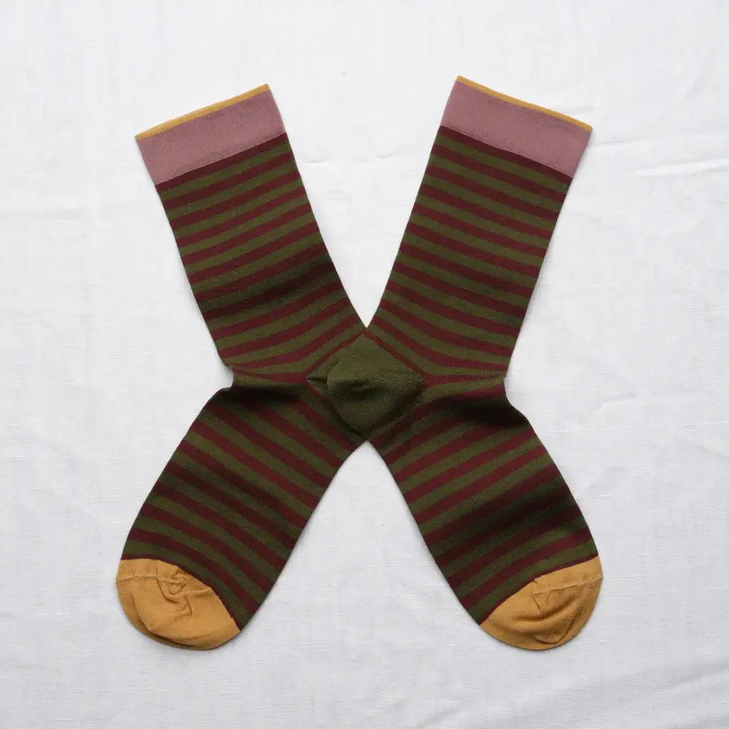 A pair of horizontal striped crew socks in an X shape on a white background. The socks feature a maroon and moss green stripe with a mauve and yellow cuff and yellow toes.