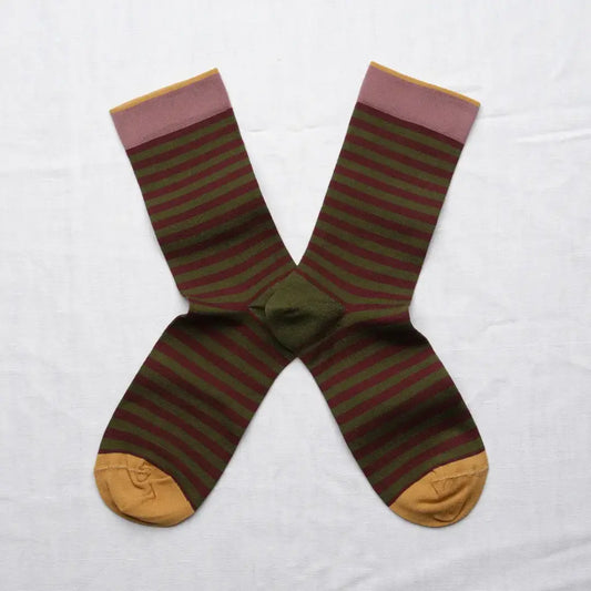 A pair of horizontal striped crew socks in an X shape on a white background. The socks feature a maroon and moss green stripe with a mauve and yellow cuff and yellow toes.