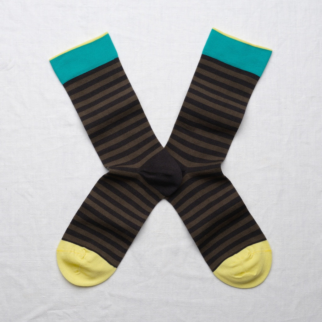 Pair of striped socks with teal tops and yellow toes on a light gray background
