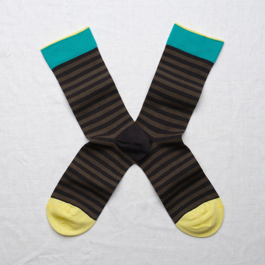 Pair of striped socks with teal tops and yellow toes on a light gray background