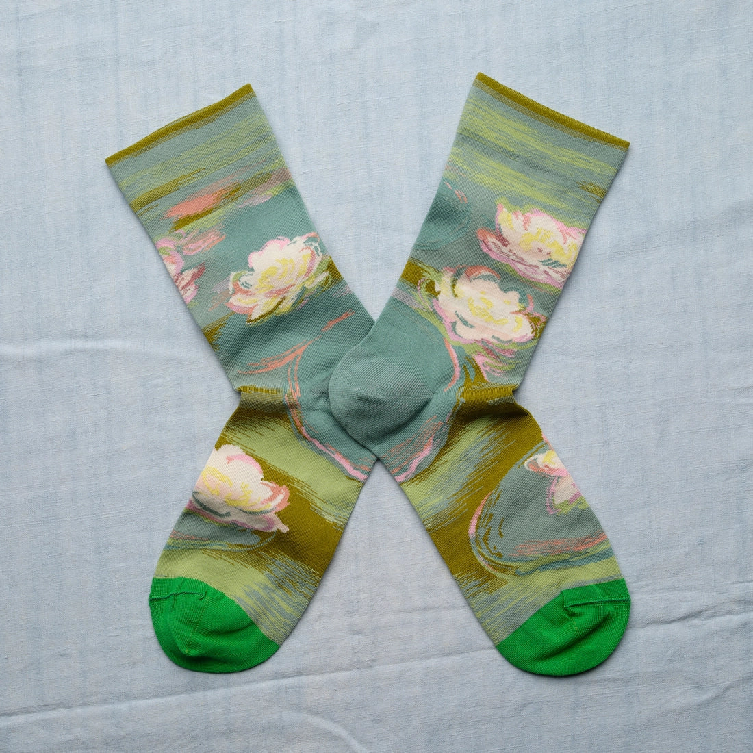 A pair of green socks with a Monet water lily design and green toes.