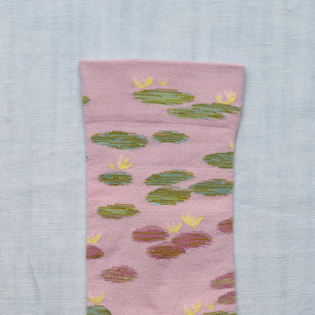 A closeup photo of a  pink socks with a monet water lily design.