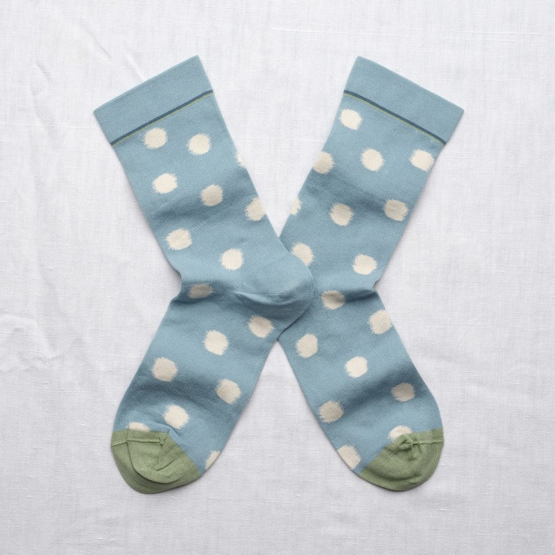 pair of mid blue socks with white polka dots and greet toe detail