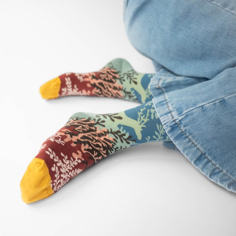 person wearing pair of socks with colorful leaf motif