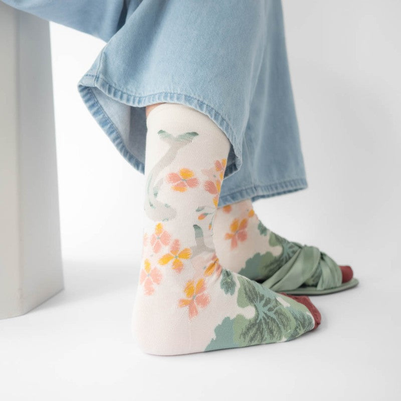 person wearing pair of socks with fish and flowers