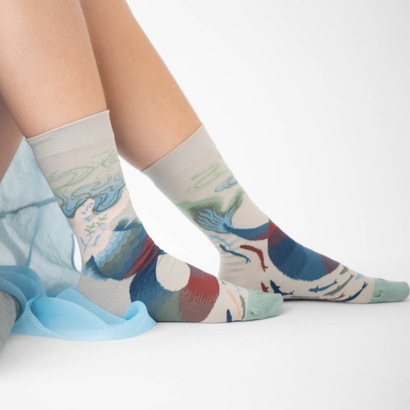 person wearing pair of socks with mermaid motif