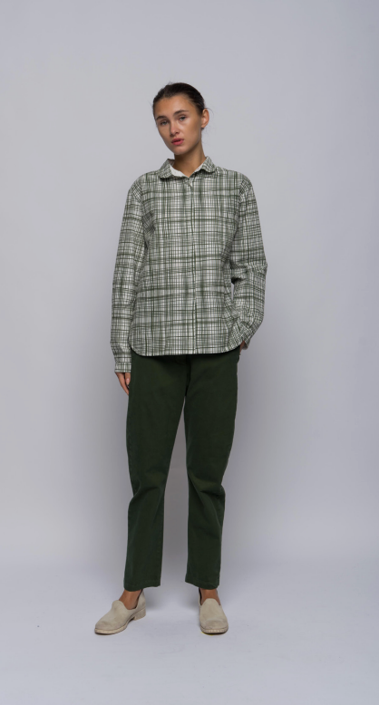 Model shown against a light grey background wearing green pants and an olive plaid collared, button-down shirt.