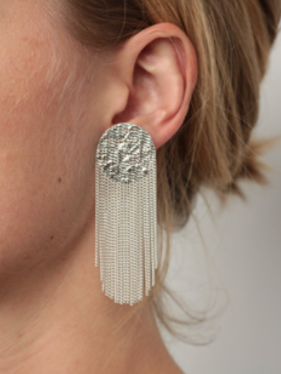 A model shown wearing silver earrings with a silver chain fringe.