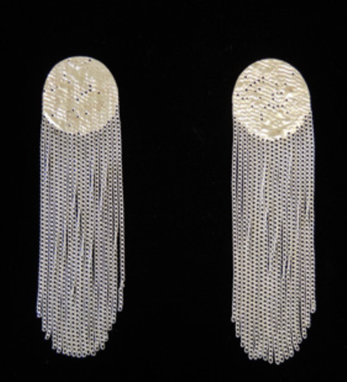 A pair of long, cylindrical silver-toned fringe earrings with textured circular tops, displayed against a solid black background.