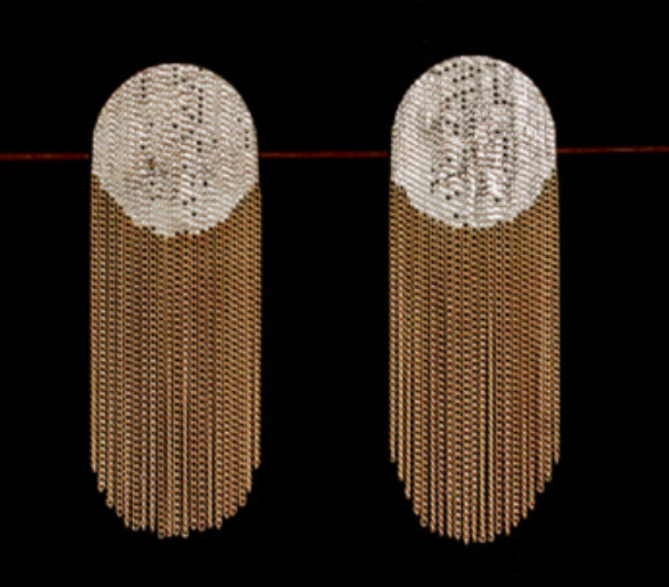 A pair of large, oval-shaped statement earrings made of clear crystals and gold-toned metal, featuring a textured top half and a cascading fringe bottom half, set against a solid black background.