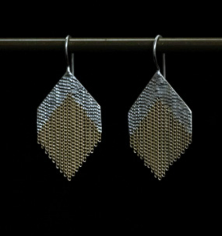 A pair of dangle earrings in a diamond shape with silver and brass chains.