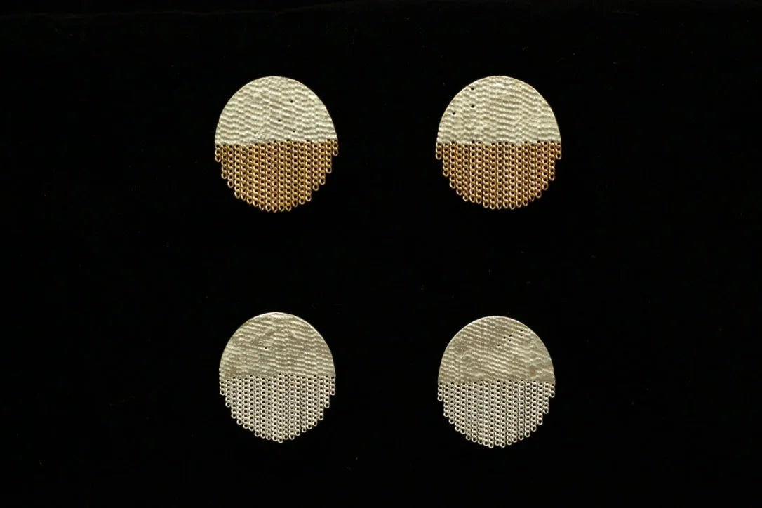 Four oval textured earrings in a two-tone brass and silver color scheme, arranged in a 2x2 grid on a solid black background.
