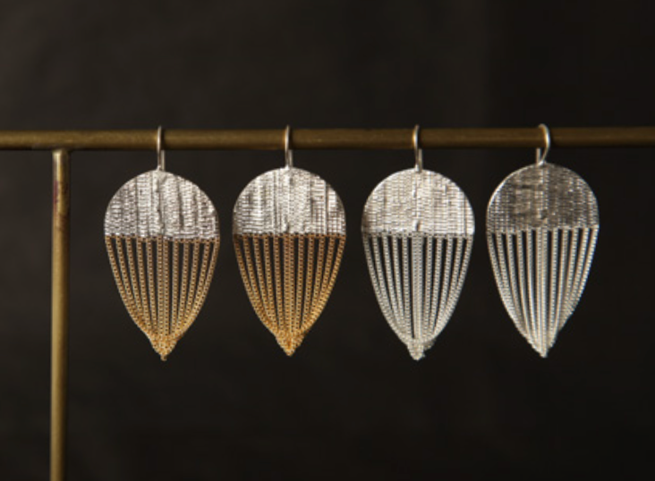 A pair of earrings with silver and brass chain earrings in a parachute-shape.