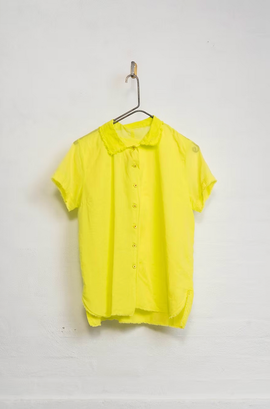 Yellow polo shirt on a hanger against a white background