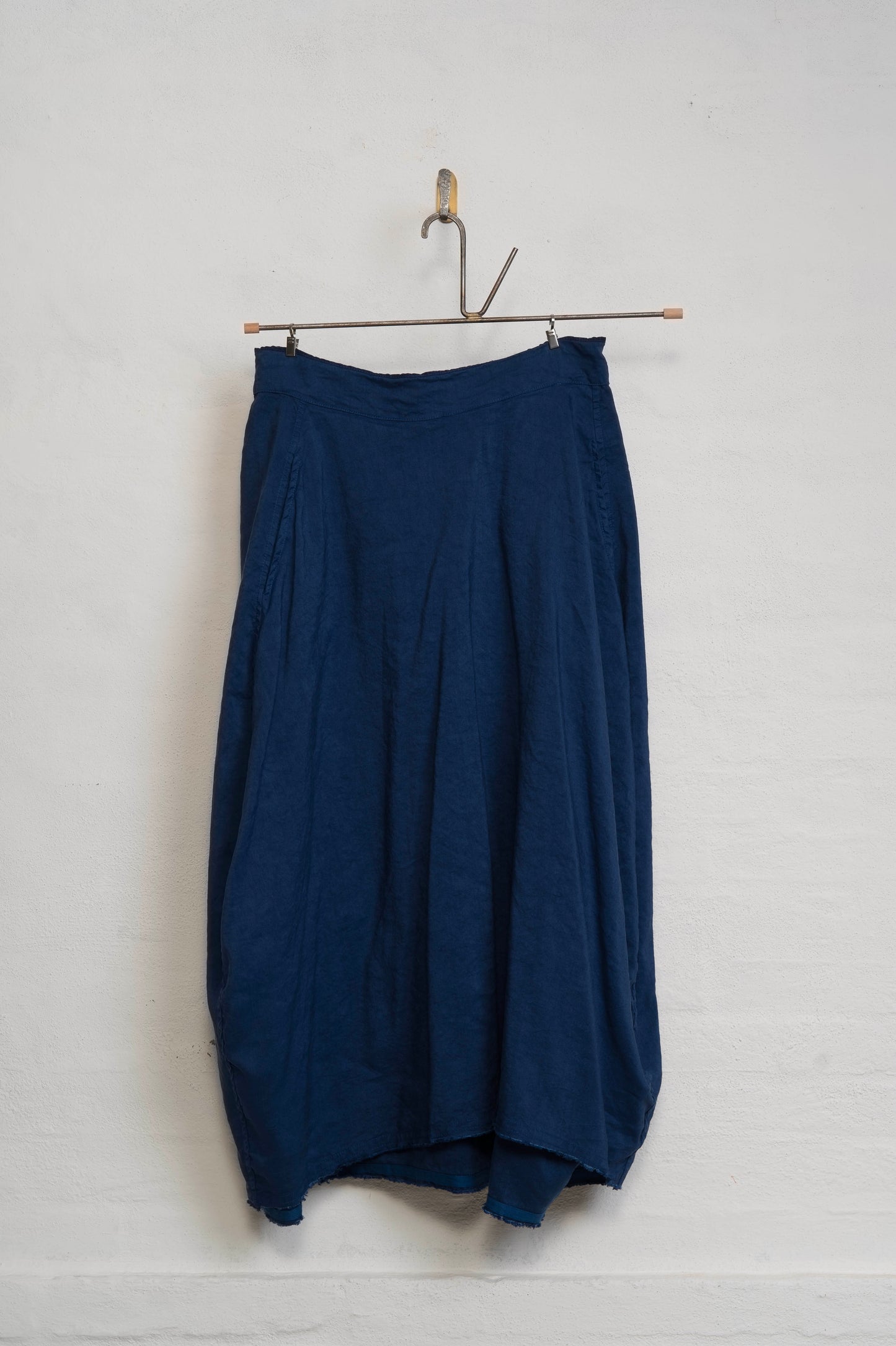 Navy blue skirt hanging on a white wall