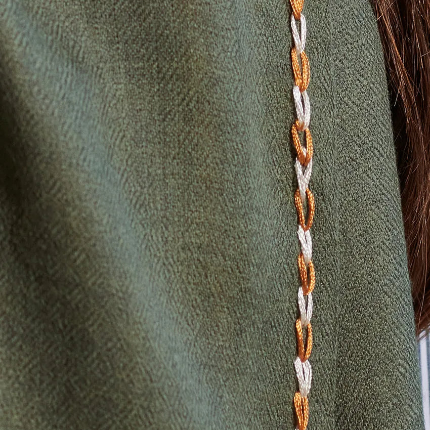 Detail of orange and white border stitch on mud color scarf