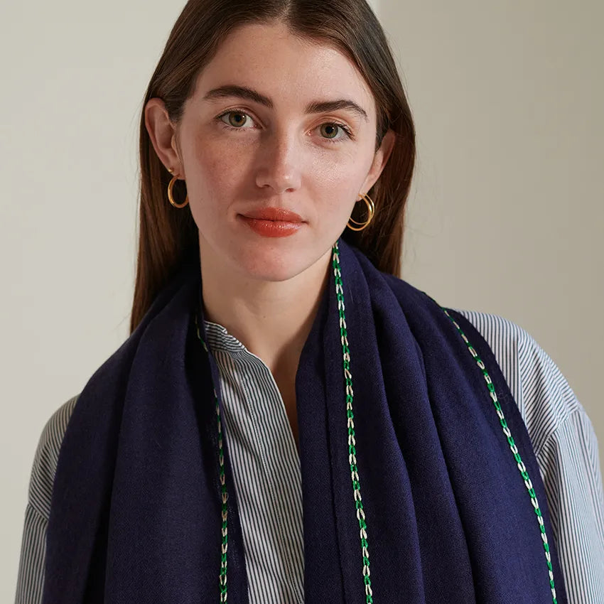 Full front view of night scarf worn over model's shoulders with green and white border stitch. Stripe shirt underneath