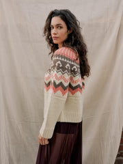Woman wearing a patterned sweater against a plain background