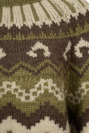 Close-up of a knitted fabric with a pattern featuring brown, green, and white colors.