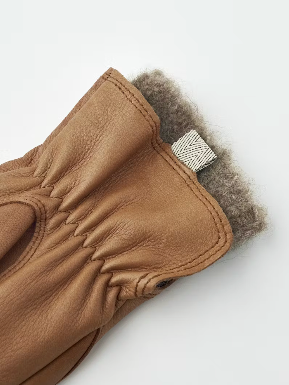 Brown leather glove with fur lining on a white background