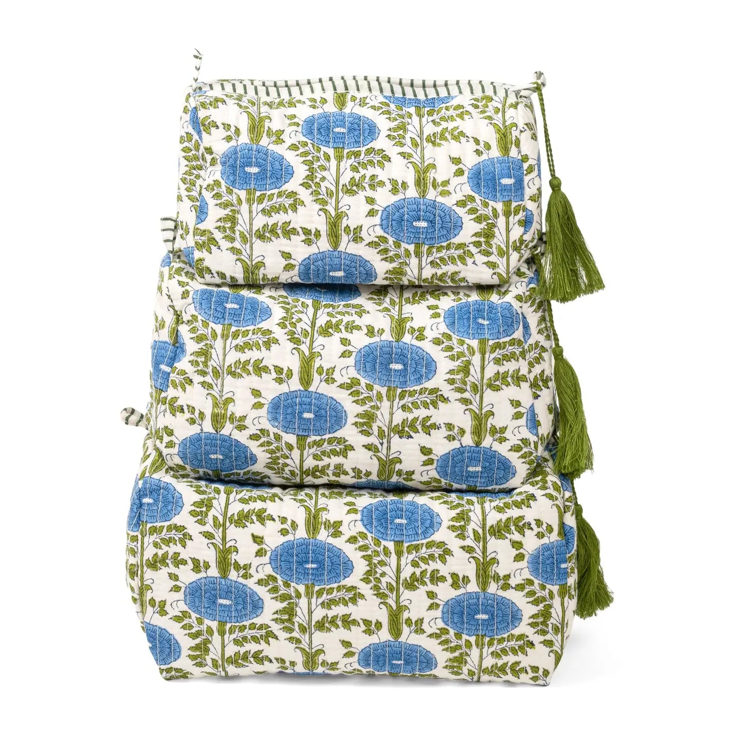 A stack of three square quilted cushions with a cream background, blue floral motifs, and green stems, finished with green tassels on the side.