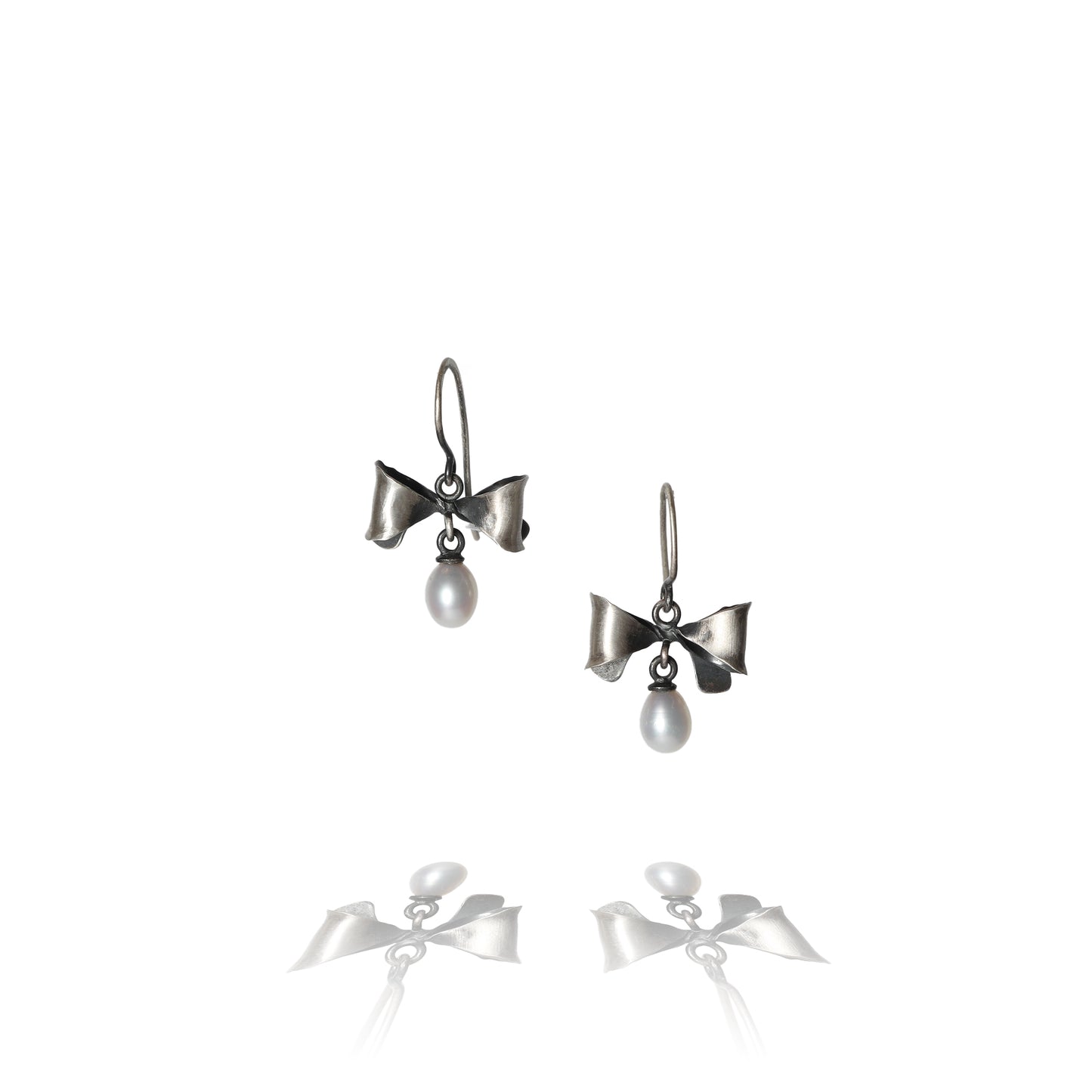 Oxidized Sterling Silver Bow Earrings with a white pearl against a white background