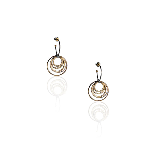 Hoop earrings in oxidized silver with gold dust and multiple swinging hoops dangling from main hoop