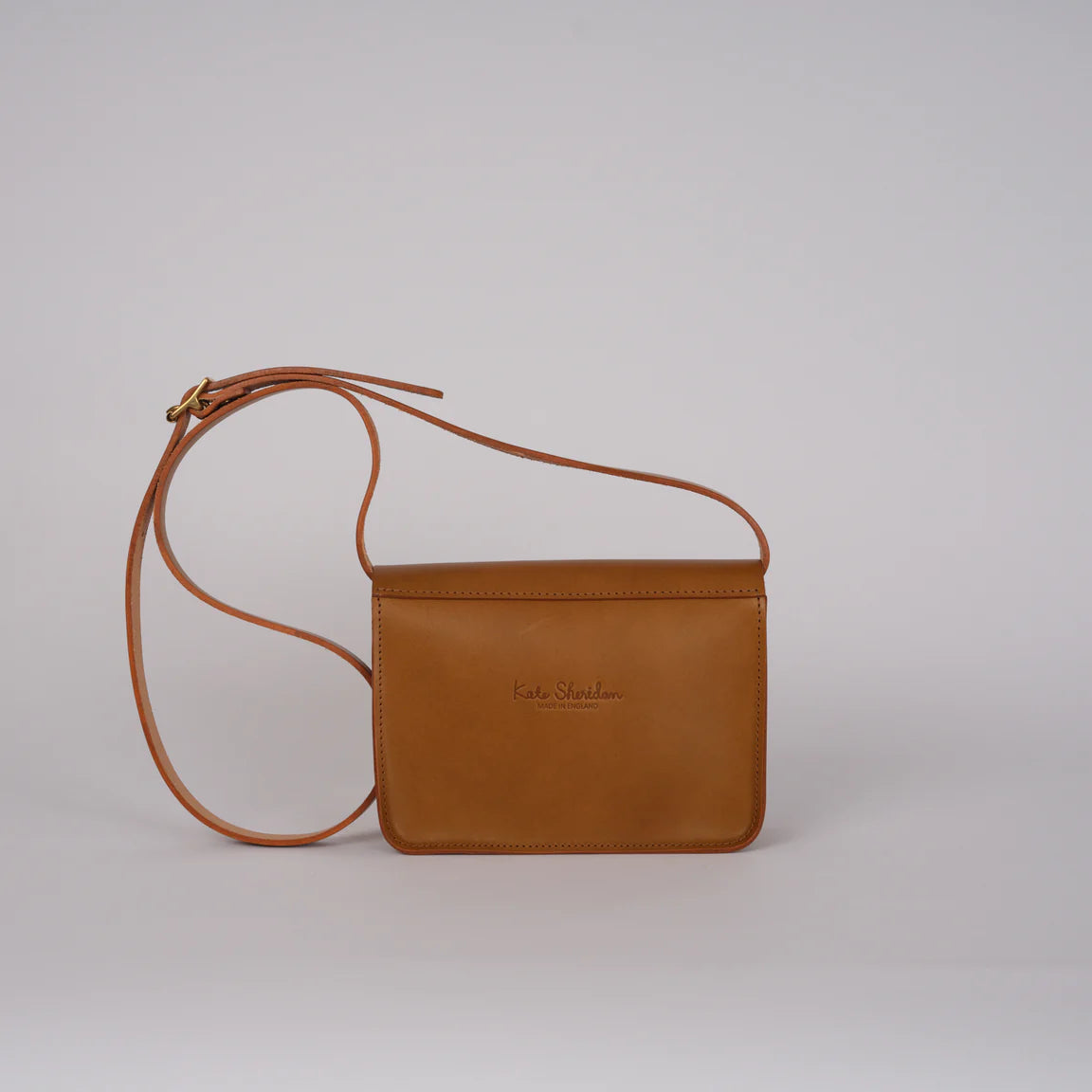 Brown leather crossbody bag on a light gray background