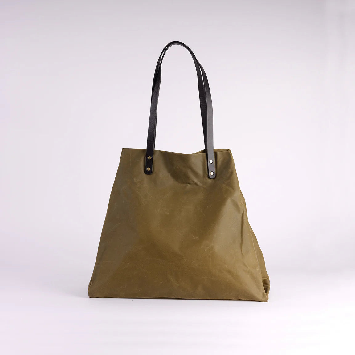 Green tote bag with black handles on a white background