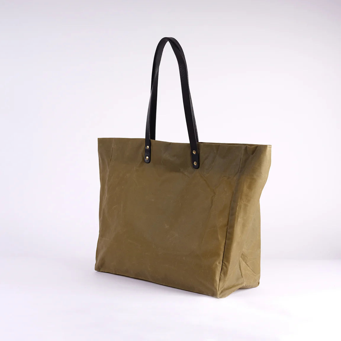 Brown tote bag with black handles on a white background