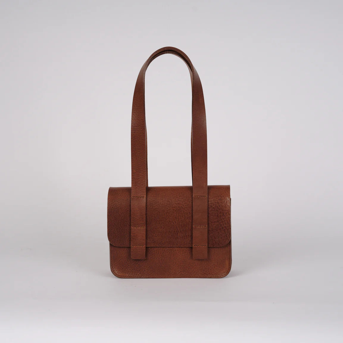 Brown leather handbag on a light gray background
