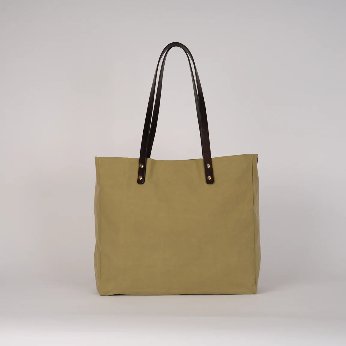 Beige tote bag with black handles on a light gray background