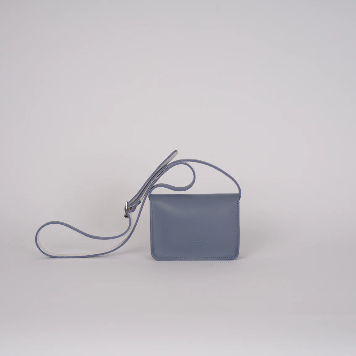 Blue handbag with a strap on a light gray background