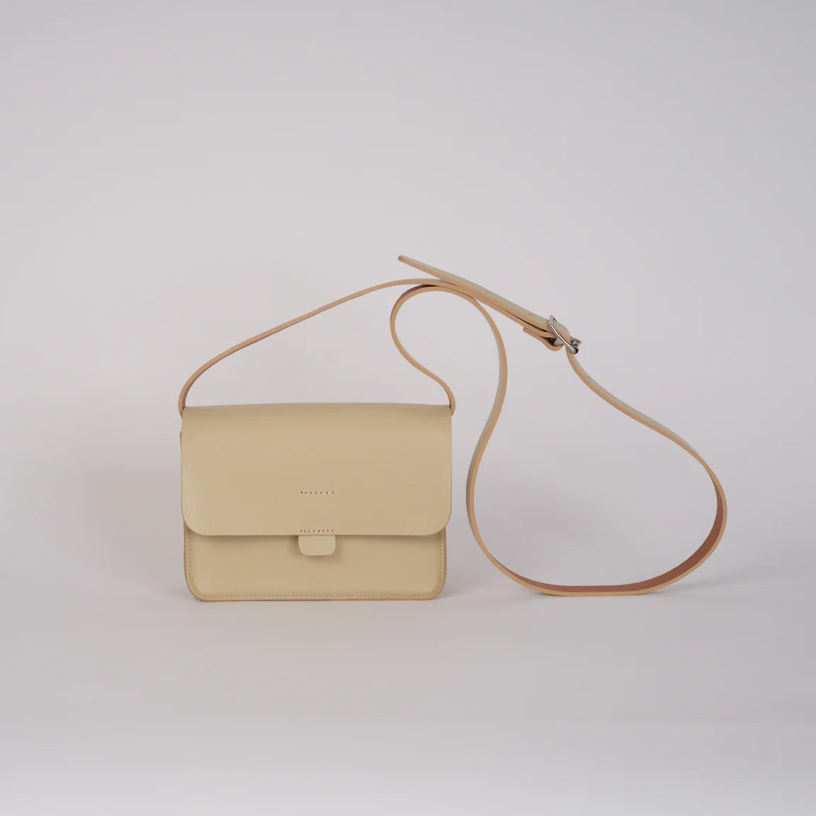 Beige handbag with a strap on a light gray background