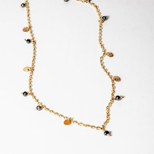 gold chain embellished with black pearls and gold discs