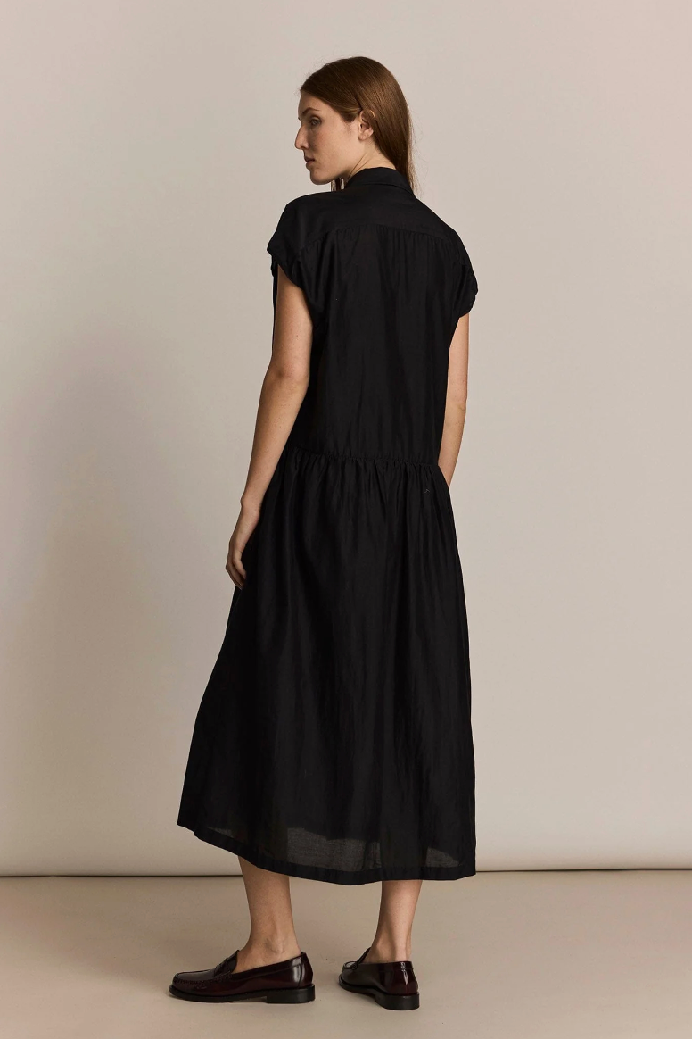 Woman wearing a black dress against a plain background