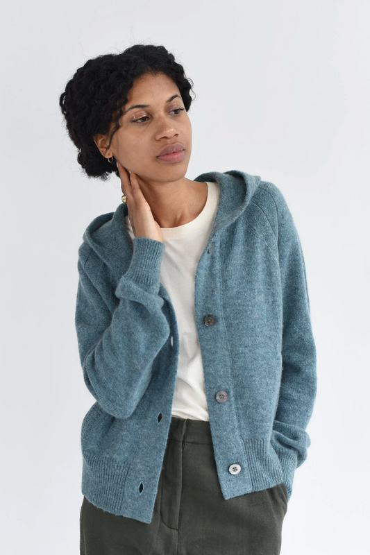 Woman wearing blue Marino wool knitted hoodie cardigan with buttons.